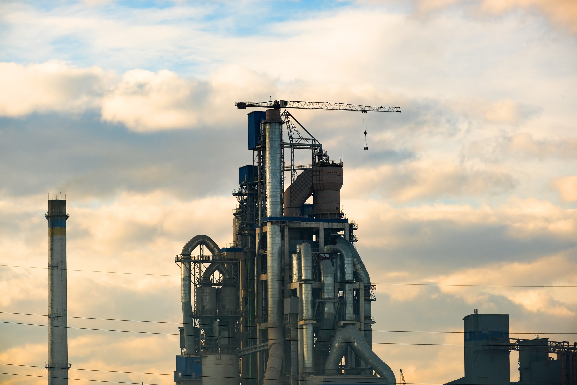 Cement plant with high factory structure and tower crane at industrial production area