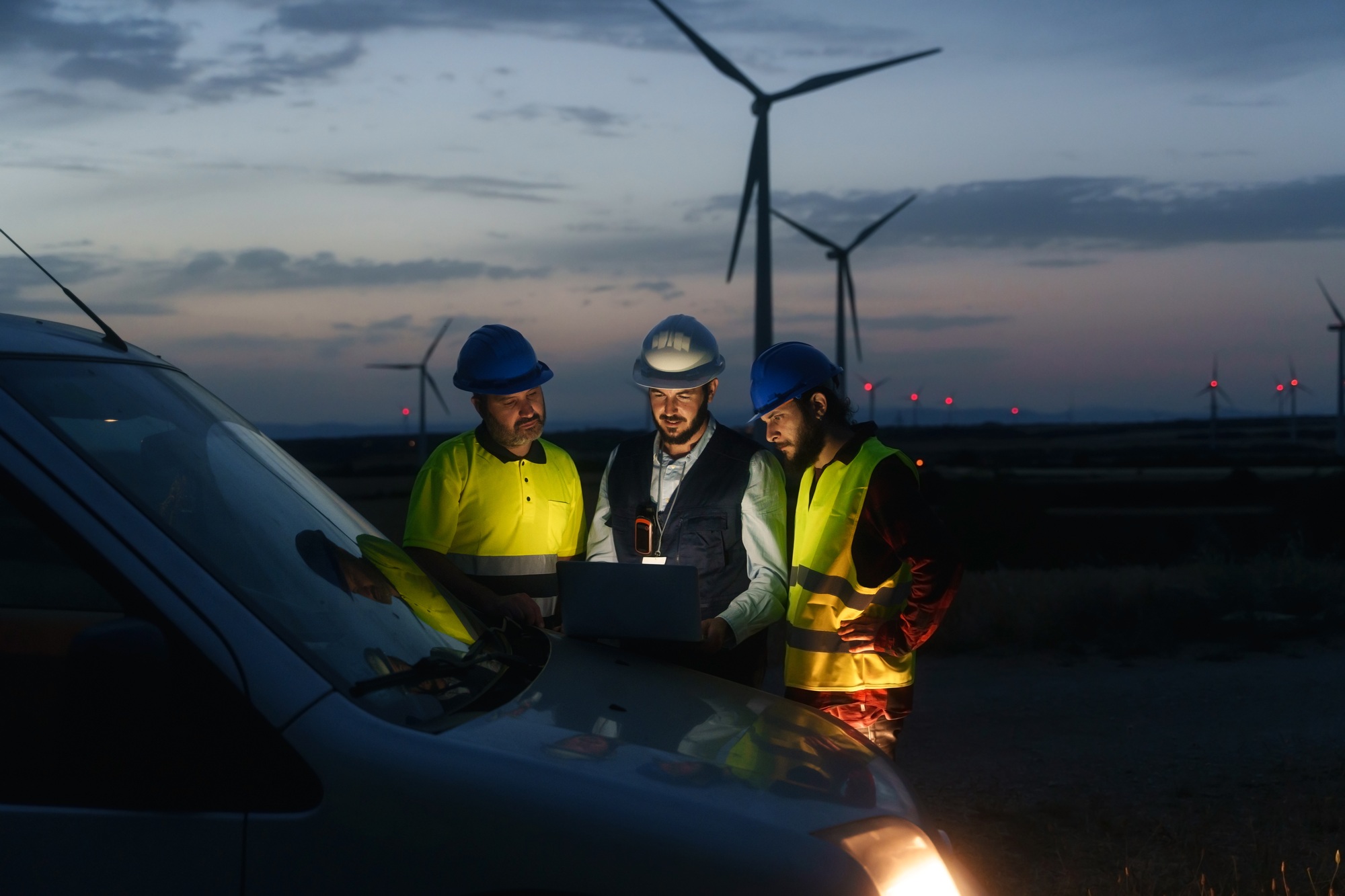 Technicians engineers working in wind turbine electricity plant at night