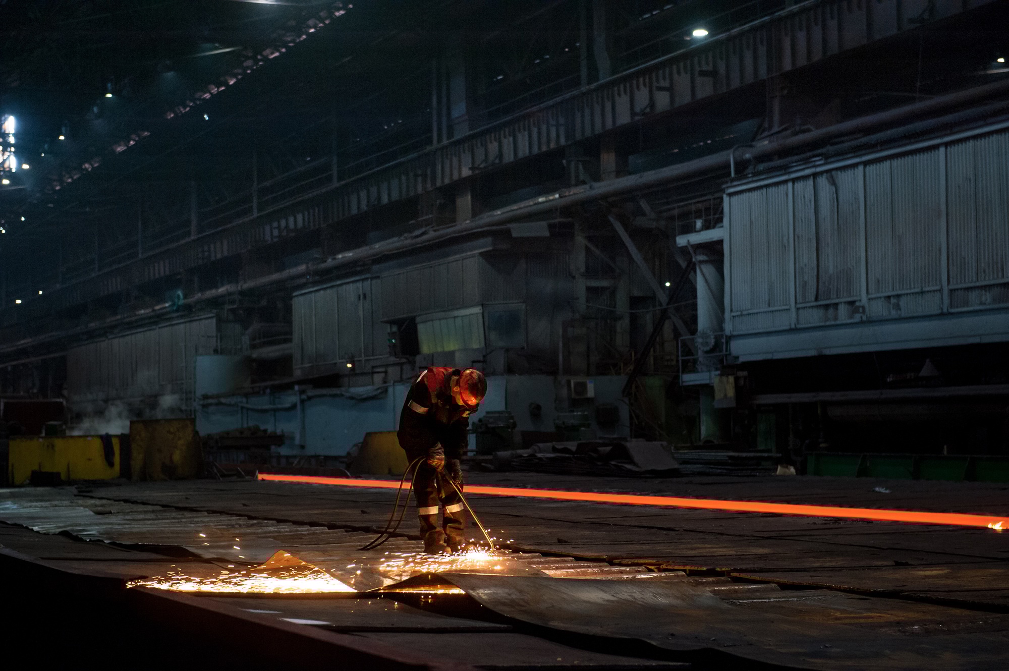 Worker doing a industrial welding at a steel mill