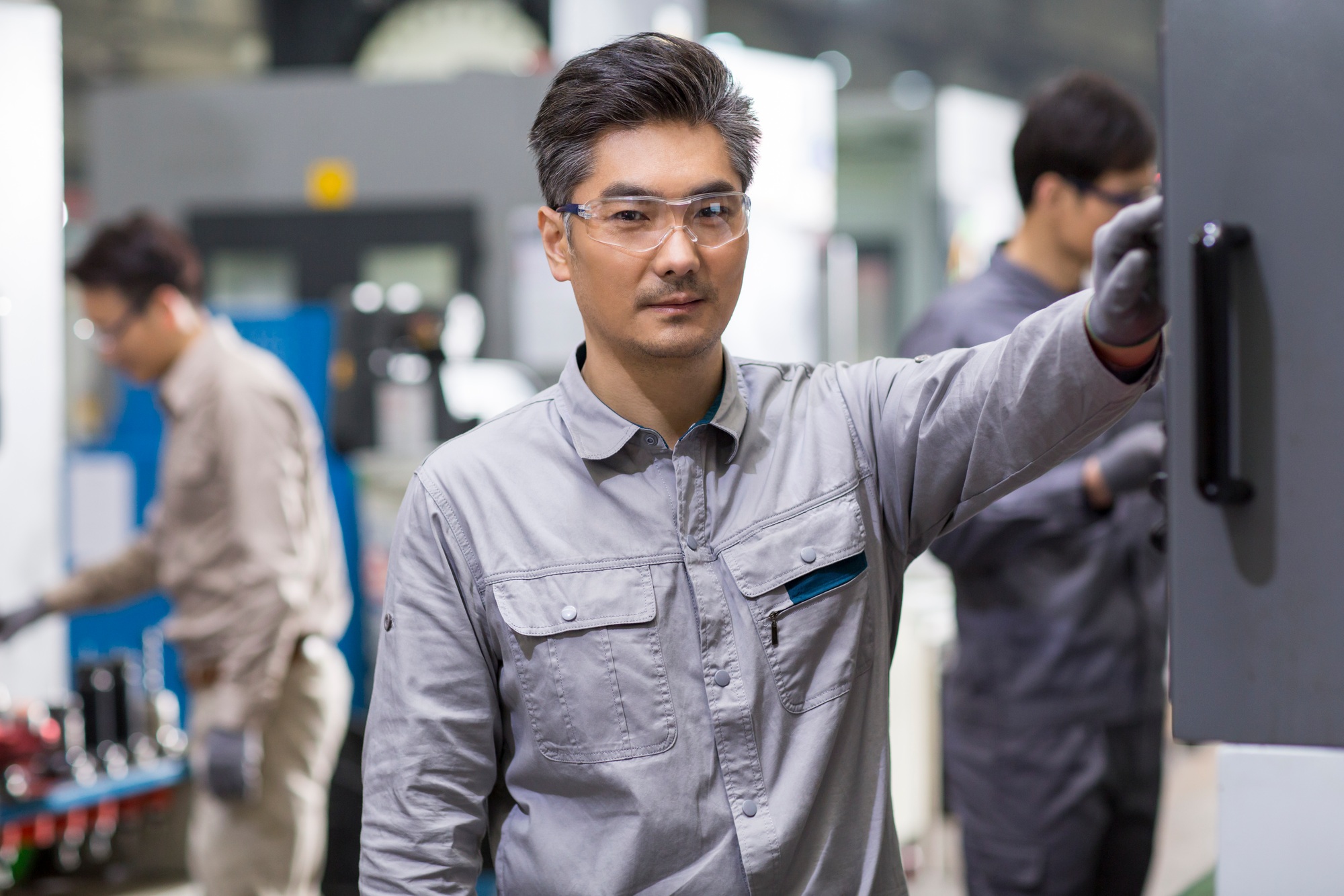 Confident engineers working in the factory